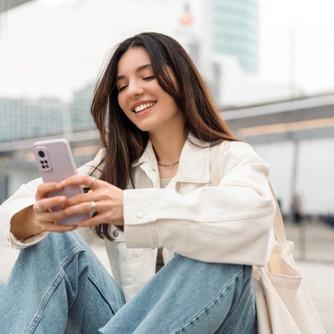Lady smiles while reading her phone