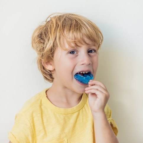 Child placing an athletic mouthguard