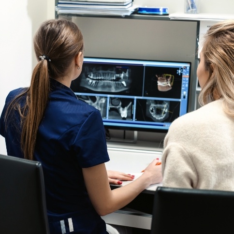 Dentist and dental team member looking at digital x rays