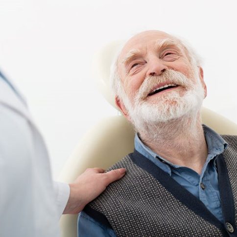 Senior male patient looking up at dentist
