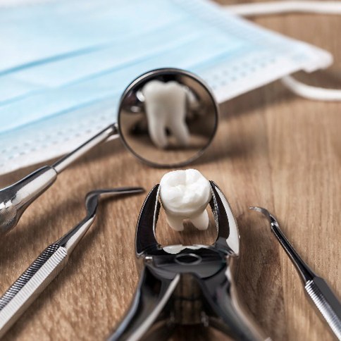 Dental tools lying on table with PPE and prop tooth