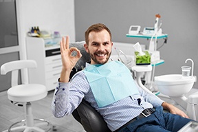 Man in dental chair giving the “okay” sign