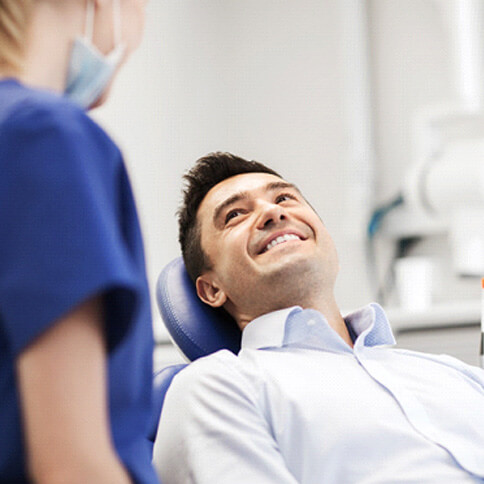 a young man smiling at his dentist from a dental chair