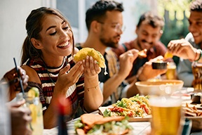 Woman smiling while eating lunch with friends at restaurant