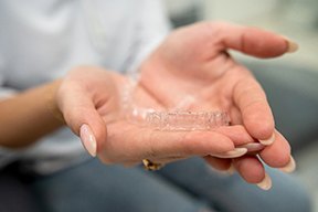 Closeup of patient holding clear aligner