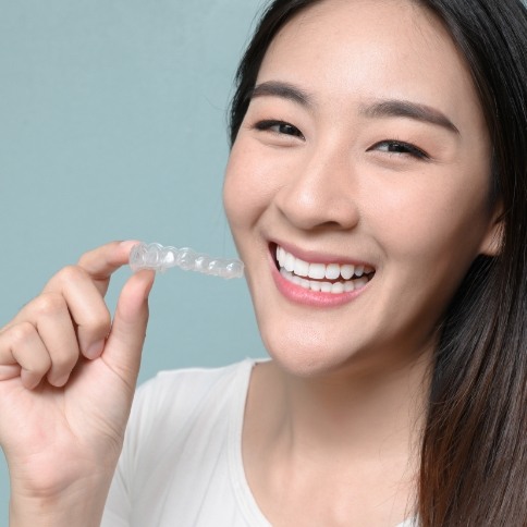 Woman holding an Invisalign aligner tray