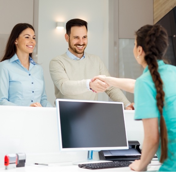 patients shaking hands with receptionist