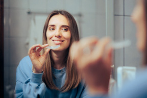 Woman smiling in the mirror with her nightguard
