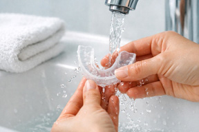 Person rinsing off their nightguard