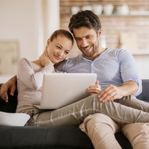 Man and woman leaving a dentist review on a laptop