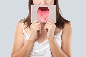 a woman holding a picture of oral cancer symptoms