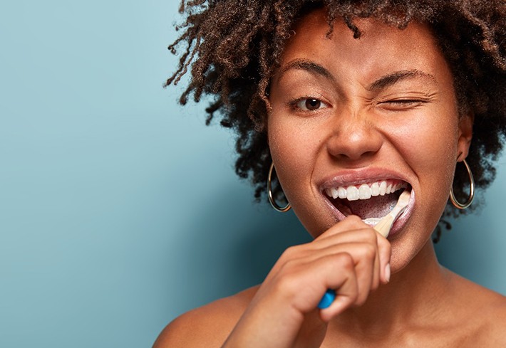 young woman brushing her teeth