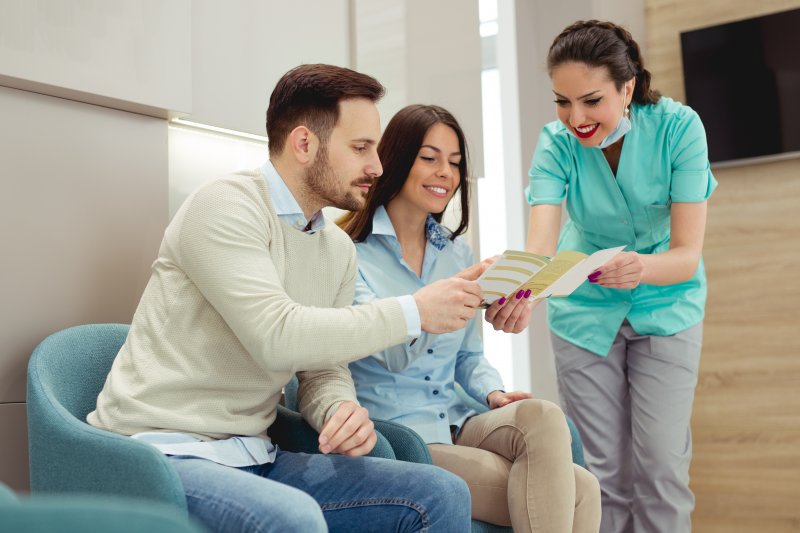 Patients discussing dental insurance with a dentist