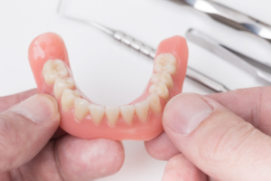 a closeup of a patient holding their dentures