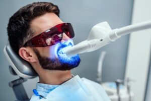 Man receiving in-house professional teeth whitening treatment